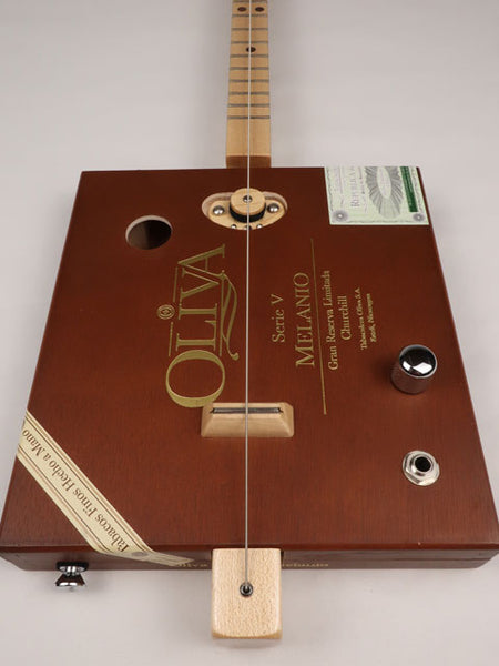 Front view of a one string cigar box guitar diddly bow cbg made with an Oliva cigar box. This cigar box guitar is handmade by Mike Snowden of Snowden Guitars.