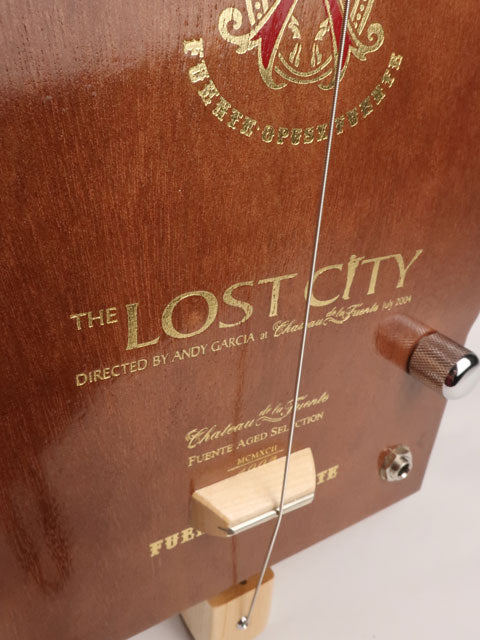 Front view of a one String diddly bow cigar box guitar CBG handmade by Mike Snowden of Snowden Guitars. This cigar box guitar is handmade with a Lost City cigar box.