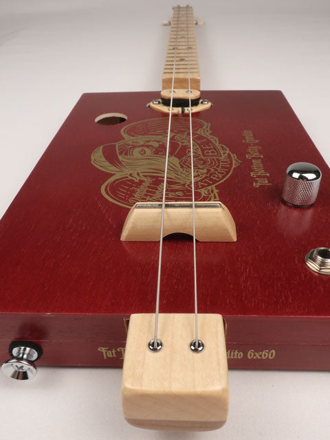 Front  tilted view of a cigar box guitar made with a Fat Betty cigar box This cigar box guitar is handmade by Mike Snowden of Snowden Guitars.
