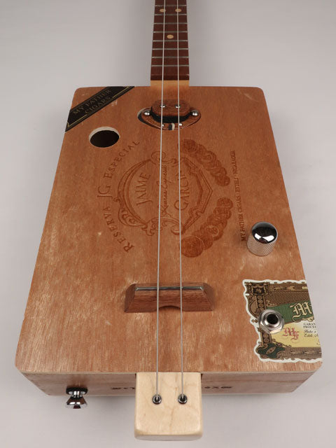 Front view of a cigar box guitar with a Jaime Garcia cigar box. This cigar box guitar is handmade by Mike Snowden of Snowden Guitars.