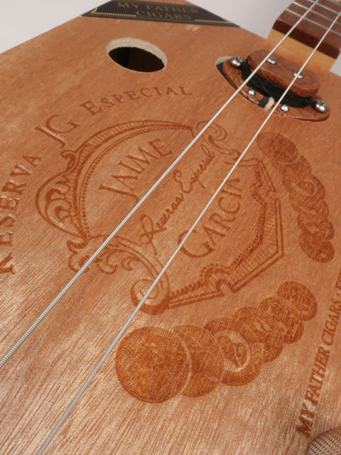 Front view of a cigar box guitar with a Jaime Garcia cigar box. This cigar box guitar is handmade by Mike Snowden of Snowden Guitars.