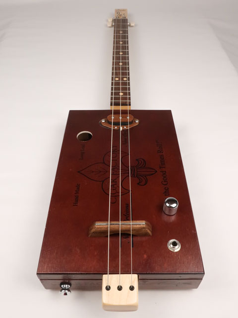 Front view of a 3 string cigar box guitar made with a New Orleans cigar factory cigar box. Handmade by Mike Snowden of Snowden Guitars.