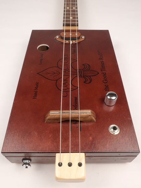 Front view of a 3 string cigar box guitar made with a New Orleans cigar factory cigar box. Handmade by Mike Snowden of Snowden Guitars.